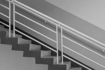 Abstract black and white image side view of architecture staircase outside of buildings.