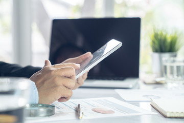 Top view hand of business team during meeting conference are working documents about the marketing plan and sales report finance of the company with laptop computer and smartphone tablet on work table