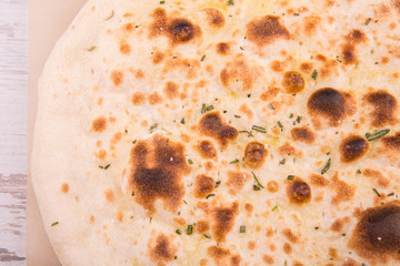Pizza focaccia with grated cheese and greens
