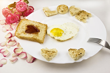 Plate with egg, fork, roses, petals, breakfast, sun, white background