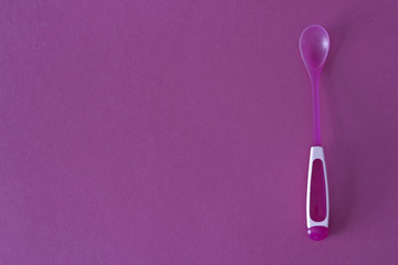 Children's spoon on a pink background