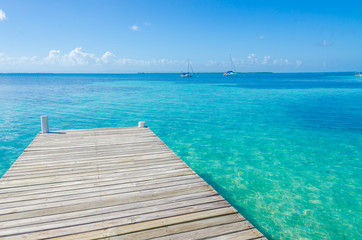 Obraz premium Belize Cayes - Pier on small tropical island at Barrier Reef with paradise beach - known for diving, snorkeling and relaxing vacations - Caribbean Sea, Belize, Central America