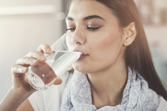 Young woman drinking pure glass of water