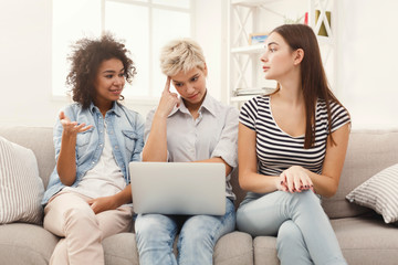 Three sad women using laptop at home