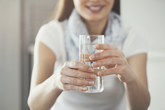 Young woman holding  pure glass of water