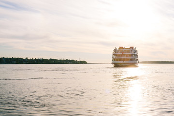 Passenger ship sailing on the river at sunset