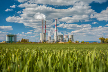 A coal-fired power station in the distance in agricultural landscape. Pocerady, Czech republic - obrazy, fototapety, plakaty