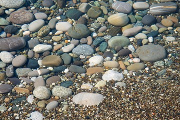 Texture of beach stones in shallow water