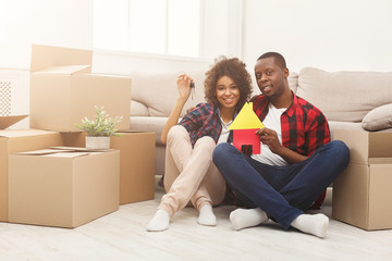 Black couple sitting on floor at new apartment