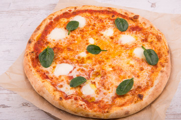 The pizza baked with pieces of mozzarella and greens