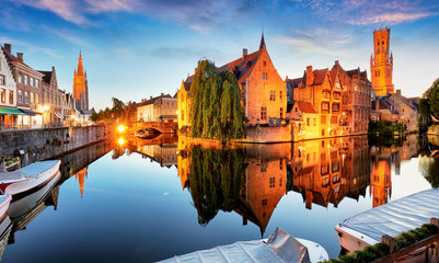 Canal in Bruges and famous Belfry tower on the background at sunset, night, Belgium