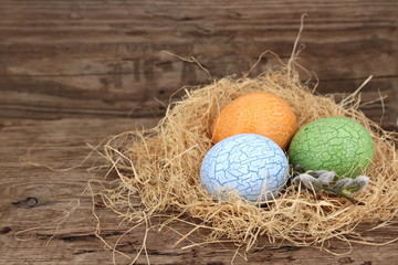 ausgeblasene, bunte Eier in einem Nest aus Stroh