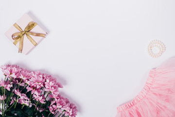 Bouquet of flowers, pink skirt, gift box and pearls