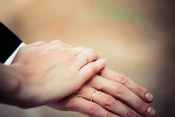 Young married couple holding hands, ceremony wedding day