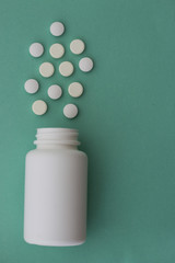 Medical pills and a plastic bottle. Blue pastel background. Medicines. Close-up. Top view. Copy space.