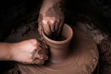 hands of a potter, creating an earthen jar on the circle