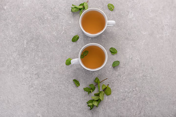 Cups of aromatic tea with mint on table