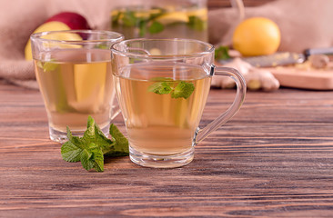Glass cups of hot tea with mint on wooden table