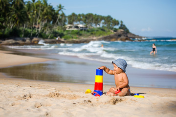 Kid plays with toys at the seashore in summertime