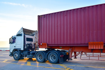 Heavy duty truck pick up shipping container at port. Logistics concept