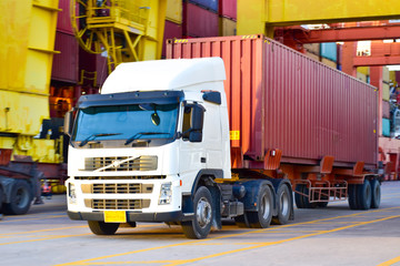 Heavy duty truck pick up shipping container at port. Logistics concept