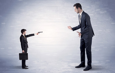 Fototapeta premium Small businessman shooting giant businessman