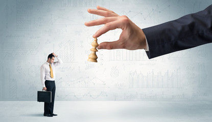 Businessman is afraid to make the next step in a chess game with graphs background
