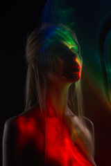 Conceptual avant-garde silhouette portrait of a beautiful blonde girl covered with multicolored...
