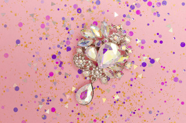 Brooch with colored crystals in spangles isolated on pink background