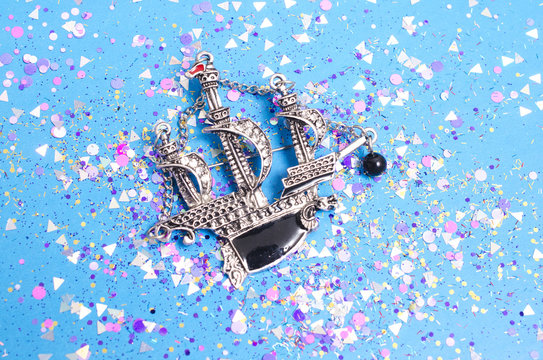 silver brooch ship with diamonds in spangles isolated on blue background