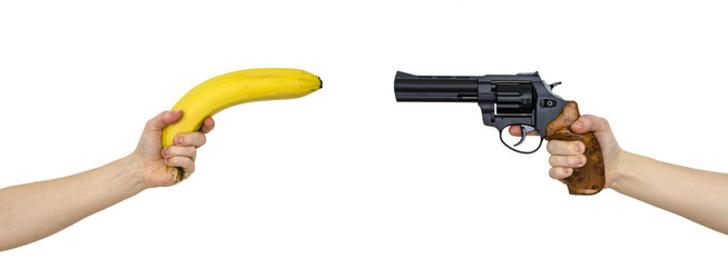 hand with a banana and a hand with gun isolated on white - 196886733