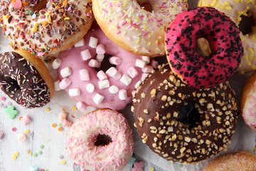 assorted donuts with chocolate frosted, pink glazed and sprinkles donuts.