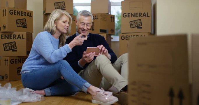 4K Couple moving in to new home taking a break to pose for selfie. Slow motion.