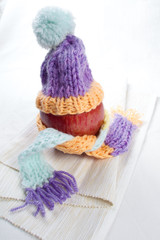 Concept of flu sick person with cap and scarf with healthy tea, fruit and vegetable