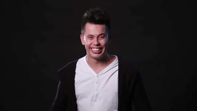 An attractive young man showing big surprise against a black background. Medium Shot