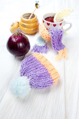 Fototapeta na wymiar Concept of flu sick person with cap and scarf with healthy tea, fruit and vegetable