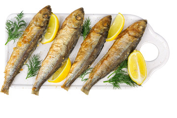fried baltic herring with lemon on cutting board isolated on white background