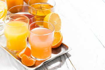 assortment of fresh citrus juices on white table