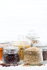 assortment of various cereals and legumes on white background, vertical