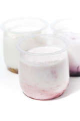 assortment of yogurts with fruit additives on white background, vertical