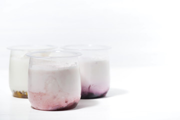 assortment of yogurts with fruit additives on white background