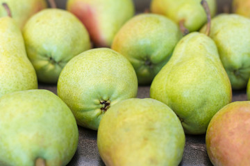 fresh green and red pears in a box in the supermarket