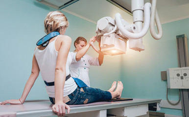 Radiologist and patient in a x-ray room. Classic ceiling-mounted x-ray system.