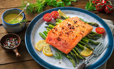 Grilled salmon garnished with green asparagus and tomatoes