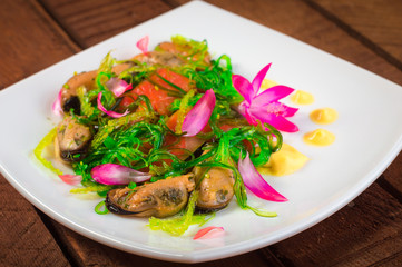 Salad with salmon, seaweed and mussels. Wooden rustic background. Top view