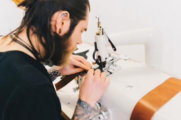 Man working with leather processes the leather with a special machine