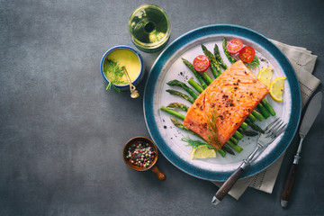 Grilled salmon garnished with green asparagus and tomatoes