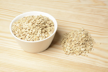 Avena cruda o copos sobre fondo de madera