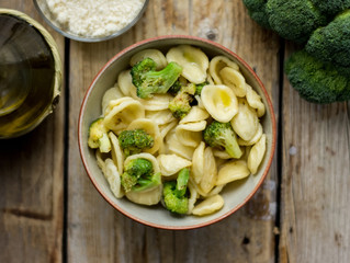 Homemade pasta orecchiette with broccoli, Italian suasage and parmesan on the wooden rustic table