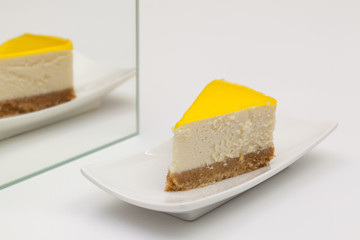 One piece of lemon cheesecake on a white  plate.